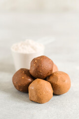 Healthy energy raw protein balls on light grey table. Fitness desserts, snacks.