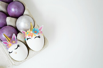 Unicorn eggs in the box on white background. Happy easter. Kids activity.