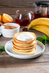Fototapeta na wymiar Pancakes with sour cream. Tasty sweet breakfast food on a table