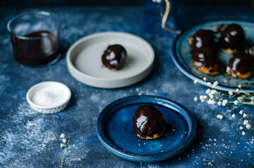 Profiterole, powdered sugar on a blue background