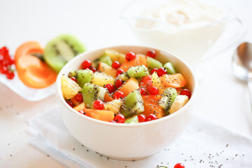 Healthy summer Breakfast concept, fruit salad in  a white bowl. Vegetarian food concept. Weight loss concept.