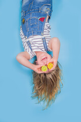 Little girl with fresh lemon near eyes