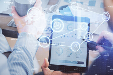 Double exposure of man's hands holding and using a phone and social network theme drawing.