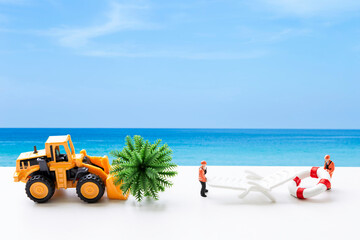 Summer concept background, yellow truck with miniature worker on the beach, beach safety