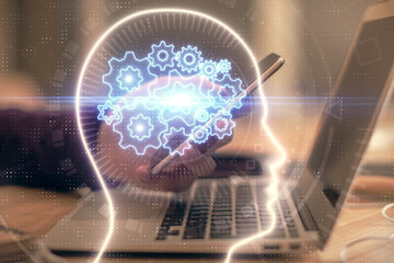 Double exposure of man's hand holding and using a digital device and brain hologram drawing. Data concept.