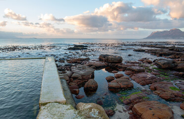 Sunrise reflections in Dale Brook Tide Swimming Pool in Cape Town South Africa RSA
