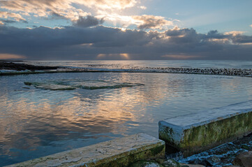 Dawn sunrise reflections over Dale Brook Tide Pool in Cape Town South Africa RSA