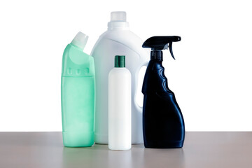 Plastic bottles with household cleaning chemicals on a wooden table are isolated on a white background. The concept of a cleaning service. A set for cleaning various surfaces at home.