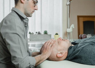 CST practitioner relieves compression in the bones of the head, sacrum, and spinal column using...