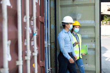 Fototapeta na wymiar Technical expert in solar photovoltaic panels holding light bulb in hand and discussion with engineer woman in new project. Engineer wearing hygienic mask and protective hard hat.
