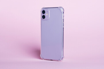 Phone case mock up side view. Purple smart phone in clear silicone case isolated on pink...