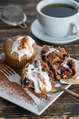Sweet cherry muffin with ice cream and white cup with tea on a wooden background
