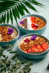 Side view on dfferent smoothie bowls with fruits and granola 