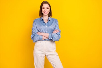 Photo of attractive confident young woman hold hands crossed smile isolated on shine yellow color background