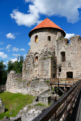 Fototapeta na wymiar Tower with a red roof of the old knight's castle in the town of Cesis, Latvia. Medieval European architecture