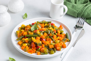stewed vegetables on a white plate, selective focus