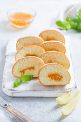 Sponge cake roll with lemon jam sliced into pieces, selective focus