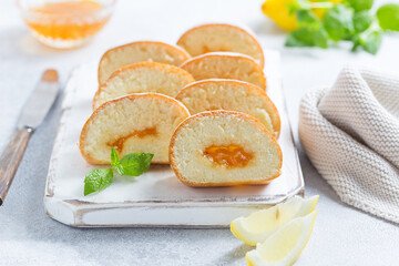Sponge cake roll with lemon jam sliced into pieces, selective focus