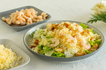 Homemade Shrimp Caesar Salad with parmesa, sauce and Croutons on a white background
