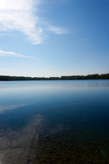 blue water quarry pond lake under blue sky and sunshine