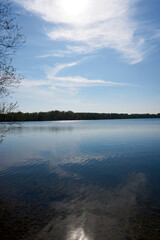 Fototapeta na wymiar blue water quarry pond lake under blue sky and sunshine