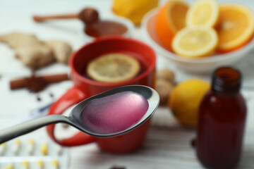 Spoon with syrup against alternative medicines, close up