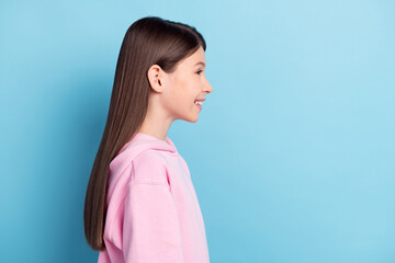 Profile side photo of young preteen girl happy positive smile look empty space isolated over blue...