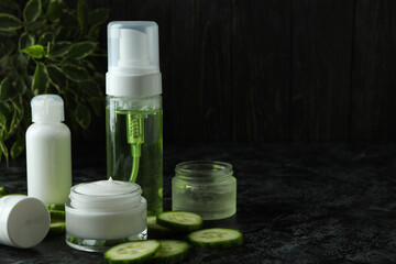 Concept of cucumber cosmetics on black smokey table