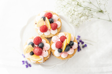 selection of sweet baked cream edible flowers and fruit dessert cakes for mothersday, wedding, birthday, paerty celebration. viola odorata cake. 