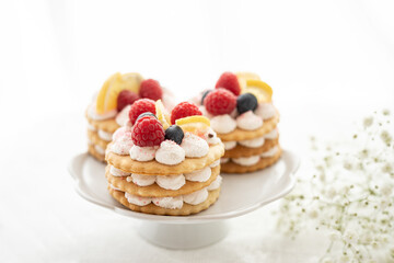 selection of sweet baked cream edible flowers and fruit dessert cakes for mothersday, wedding, birthday, paerty celebration. viola odorata cake. 