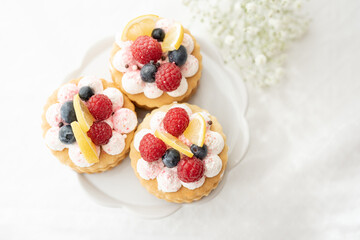 selection of sweet baked cream edible flowers and fruit dessert cakes for mothersday, wedding, birthday, paerty celebration. viola odorata cake. 