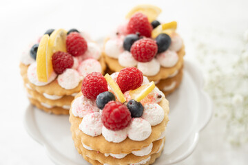 selection of sweet baked cream edible flowers and fruit dessert cakes for mothersday, wedding, birthday, paerty celebration. viola odorata cake. 
