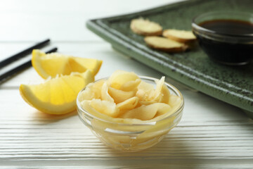 Concept of tasty eating with pickled ginger on white wooden background
