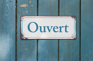 Old sign with the inscription Open in french - Ouvert