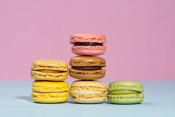French dessert macaron on pink and blue background. Modern Macarons on colorful background. copy space.