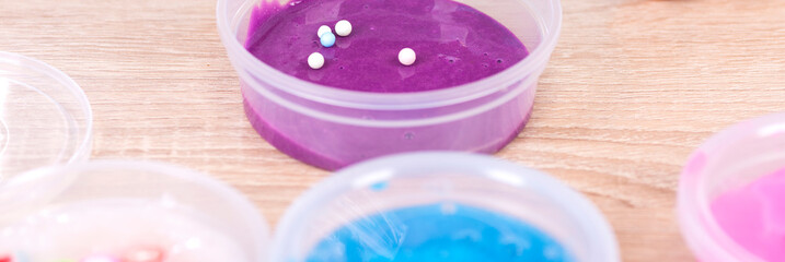 A lot of slimes on the table in jars. Putting the balls into the slime