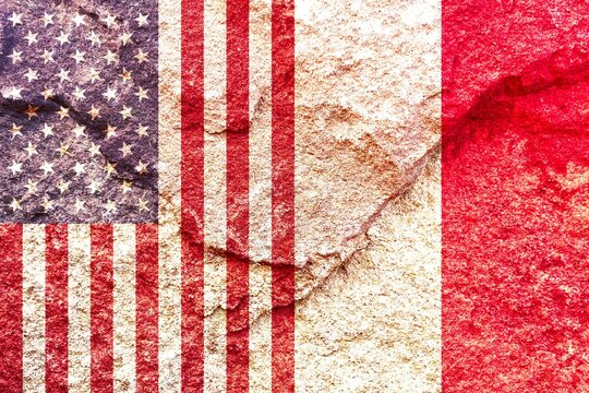 US (United States) and Poland vertical national flags together on weathered rock wall background, abstract US Poland politics relationship partnership concept
