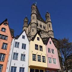 Obraz premium small colorful houses in front of the church of great st. martin in cologne's old town
