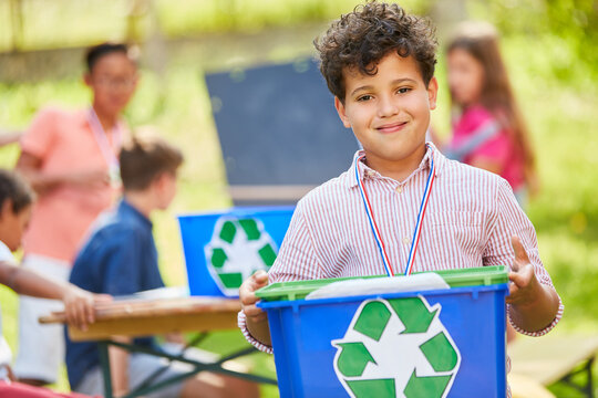Boy carries box with recycling symbol