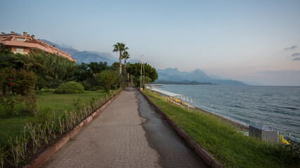 Obraz premium The embankment in the Turkish city of Kemer. The coastline. The Mediterranean Sea. Dawn on the sea. Seashore. Dawn on the beach.The road along the sea.