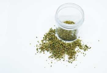 Ground buds of medical marijuana stored in plastic jar. Closeup on medical hemp blend isolated on white background. CBD, medical hemp in container.