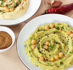 Green colored hummus - vegan chickpea legume dish, closeup, vegan bean protein dip food, healthy vegetarian eating concept