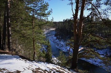 Obraz premium picturesque landscape of early spring on the river on a sunny day. Snow melting, nature awakening