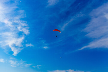 Paragliding in blue sky. Parachute with paraglider is flying. Extreme sports, freedom concept