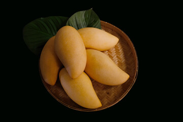 Mangoes fruit in rattan basket on black Background