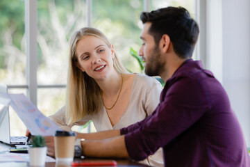 Two businesspeople, man and woman, working together in a modern office in an intimate manner. Idea for teamwork and good business colleagues