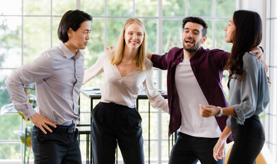 Group of diverse businesspeople, caucasian and Asian, dancing together with happiness and intimate in office. Idea for teamwork and good business colleagues