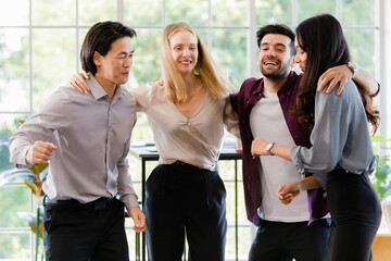Group of diverse businesspeople, caucasian and Asian, dancing together with happiness and intimate in office. Idea for teamwork and good business colleagues