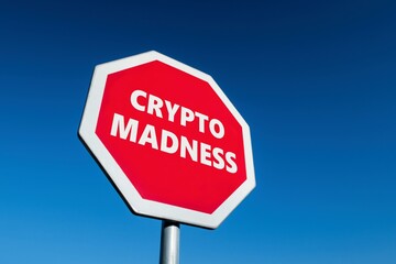 Stop traffic sign with a text CRYPTO MADNESS which wants to protest against cryptocurrencies