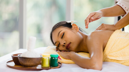 beautiful Asian woman enjoy getting an oil massage happily in a spa. Relaxing and healing with Thai massage and aroma oil. Body care and treatment, alternative medicine concept